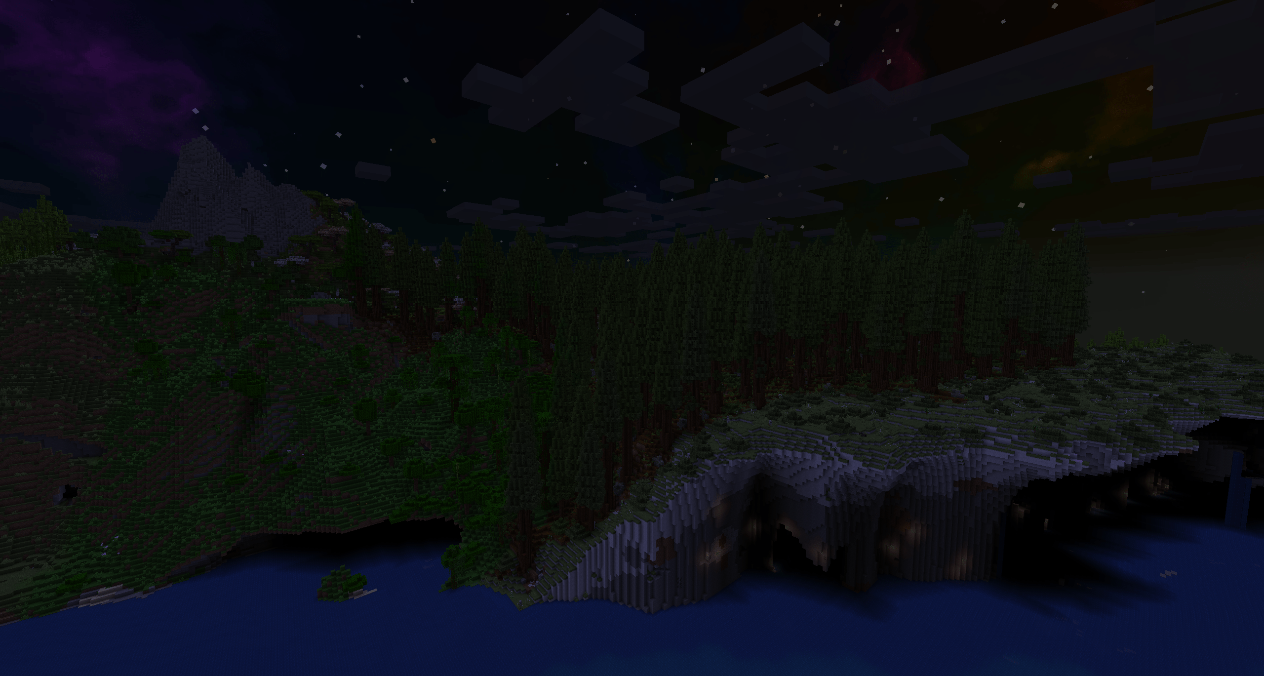 Scenery next to the ocean, worldgen image. Chalk cliffs hang over the water on the right, topped by a meadow leading into a redwood forest. On the left, hilly jungle terrain leads to stony mountains. Photo at night.
