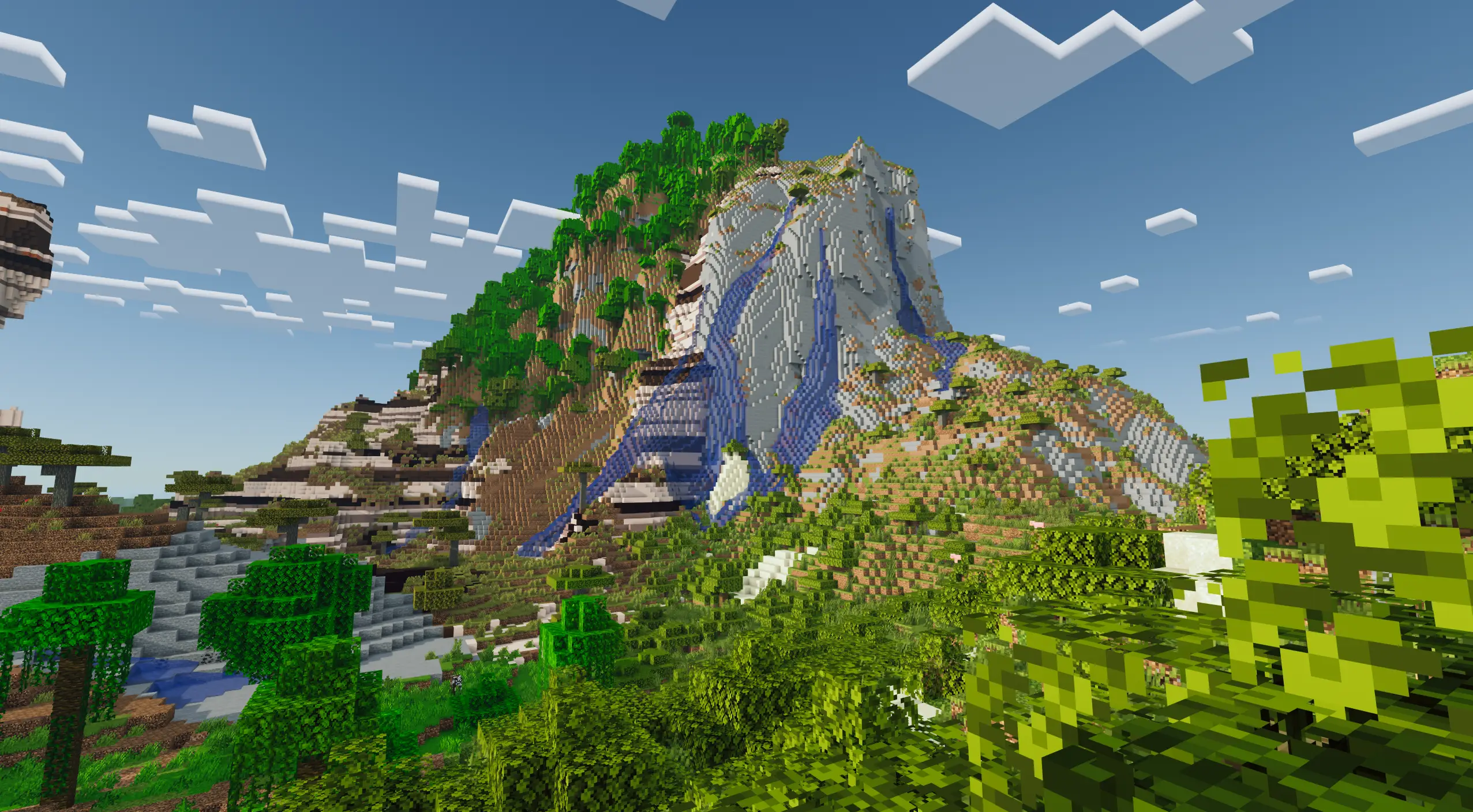 A windswept savanna combining with a jungle on the side of a cliff. Terrain generated with Terralith