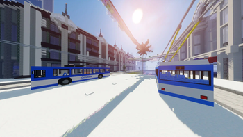 Trolleybuses on a snowy street.