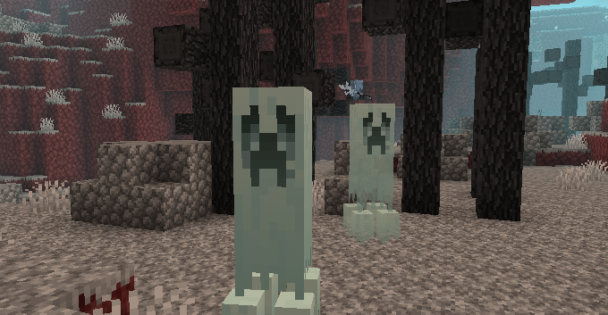 Two ghostly Creepers in the gray biome. They are three blocks tall and surrounded by dead trees.