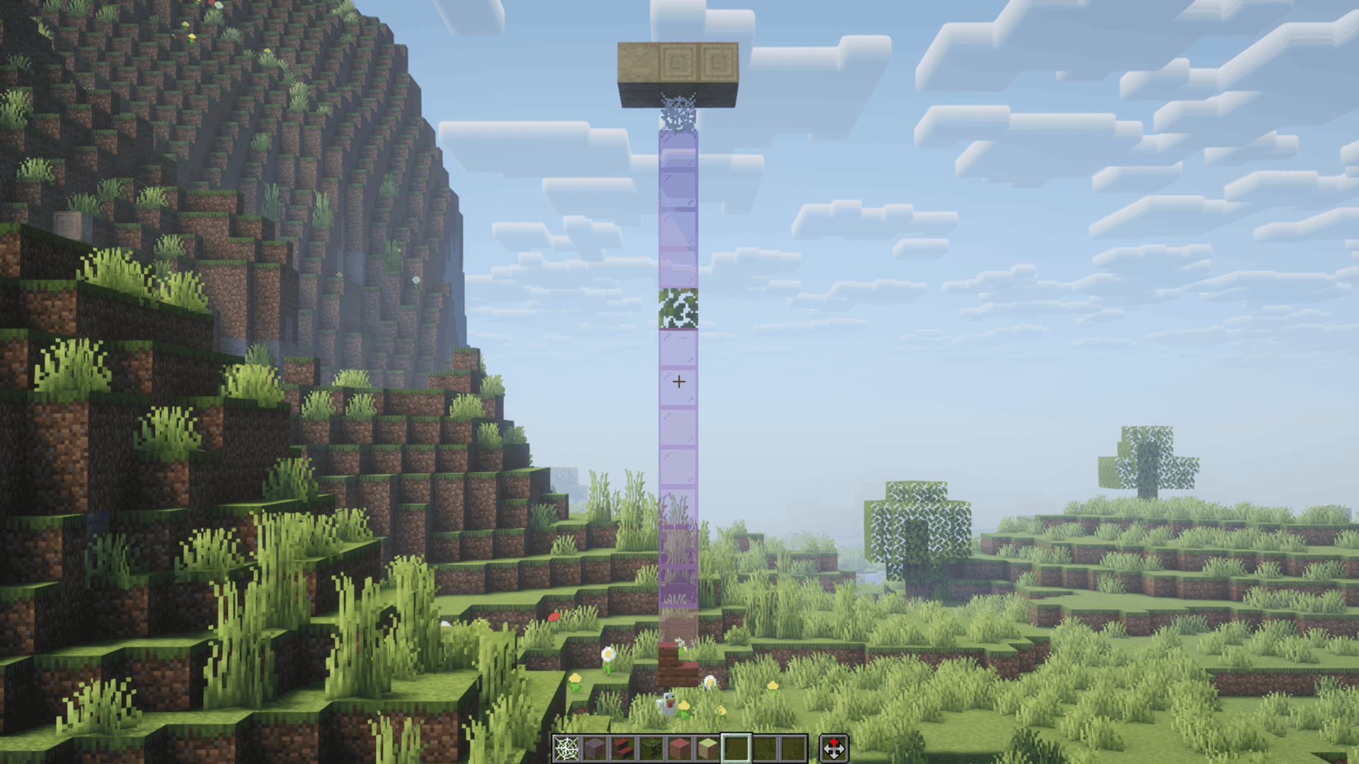 A Minecraft screenshot illustrating the block placement order for setting up the Spider-Man and Gwen Stacy custom scene. A vertical pillar of blocks extends downward from a floating stone platform to the ground against a grassy mountain background. From bottom to top, the setup shows Mangrove Stairs placed one block above the ground, followed by Pink Stained Glass, a stack of Magenta Stained Glass interrupted by a Jungle Leaves block in the middle, a Cobweb attached directly beneath the top platform, and a stone support block at the peak.  Assembly Tutorial (Reverse Placement Order: Bottom to Top) To ensure the custom 3D models and web strands line up correctly in-game, place the blocks starting from the bottom near the ground and building upwards: 1. Mangrove Stairs (Gwen Model): Place 1 block above the ground to form the base of Gwen’s model.  2. Pink Stained Glass (Gwen's Web Wrap): Place directly on top of the Mangrove Stairs. 3. Magenta Stained Glass (Lower Web Line): Place a stack extending upward to build the lower web section. 4. Jungle Leaves (Spider-Man Model): Place on top of the lower Magenta Stained Glass column where Spider-Man will cling. 5. Magenta Stained Glass (Upper Web Line): Place a stack extending upward from Spider-Man toward the top anchor. 6. Cobweb (Ceiling Web Wrap): Place directly above the highest glass block, attaching to your ceiling or anchor platform.