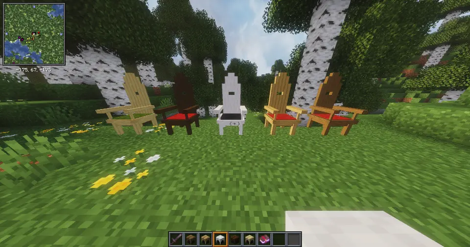 This image displays five different variants of a high-back wooden chair, placed side-by-side on a grass surface within a Minecraft birch forest environment. Each chair features a distinctively tall, stepped backrest that reaches a peak in the center, giving it a throne-like appearance. The chairs include sturdy armrests with visible wood-grain circular textures on the front ends and a small rectangular cutout in the upper portion of the backrest. The seats are topped with a thick, textured fabric cushion. In the background, a lush birch forest and a clear blue sky are visible, along with a mini-map in the top-left corner of the interface.