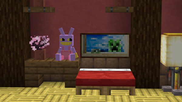 Jax plush sitting on a table next to a bed in minecraft