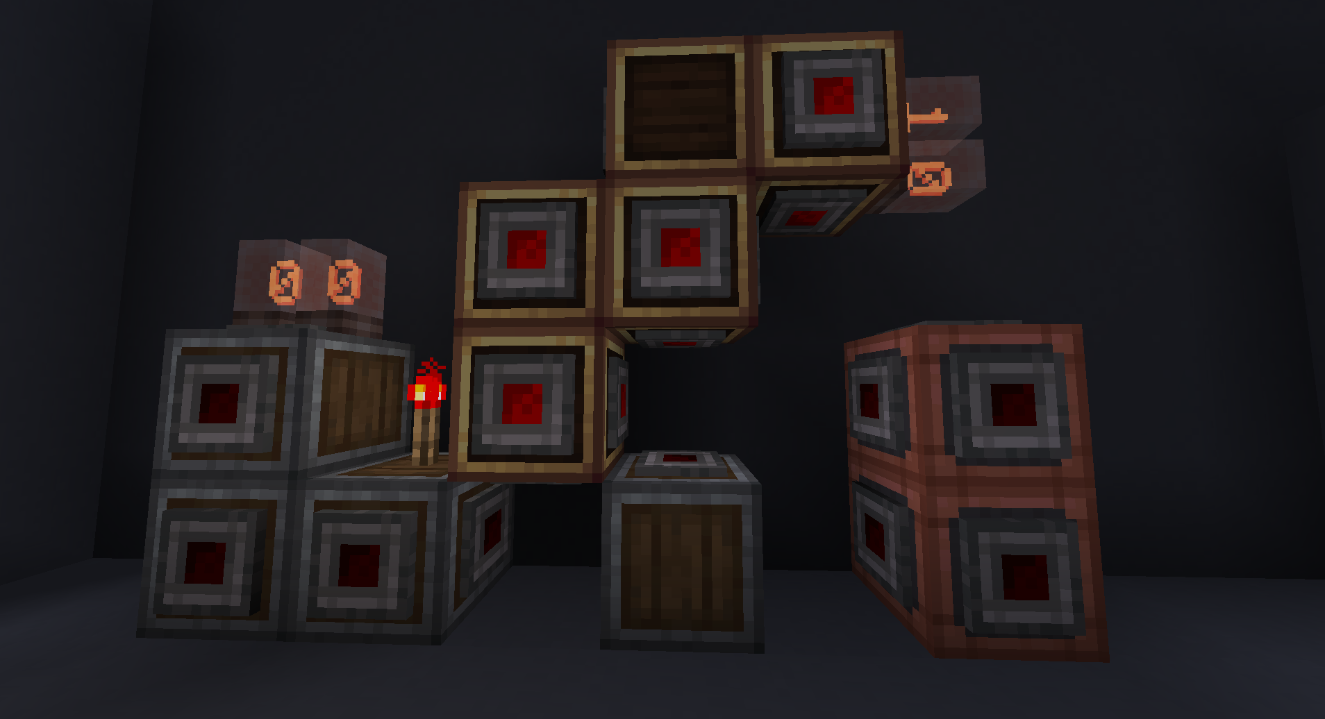 A bunch of Encased Redstone Blocks attached to a wall. Left, Andesite; middle, above ground, Brass; right,  Copper. Some Connectors are missing preventing redstone conduction.