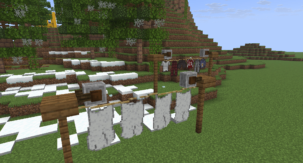 a couple clotheslines holding sheets, shirts, pants.