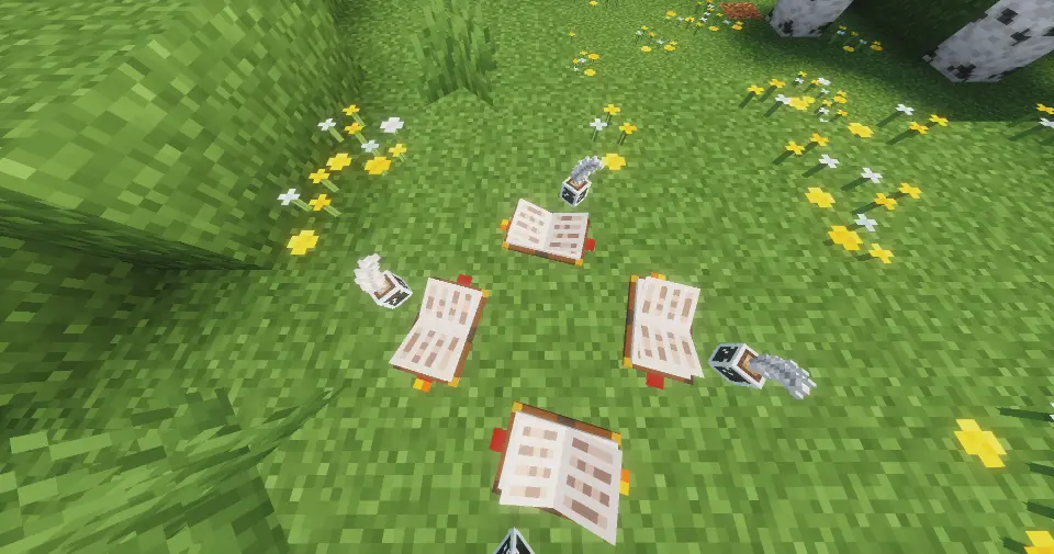 This top-down perspective shows four identical Scribe's Sets arranged in a circular pattern on a grassy Minecraft floor. Each set consists of two separate decorative elements. The items are placed in a natural setting among green grass, small yellow dandelions, and white flowers. The lighting is bright and sunny, consistent with a clear day in a Minecraft world.