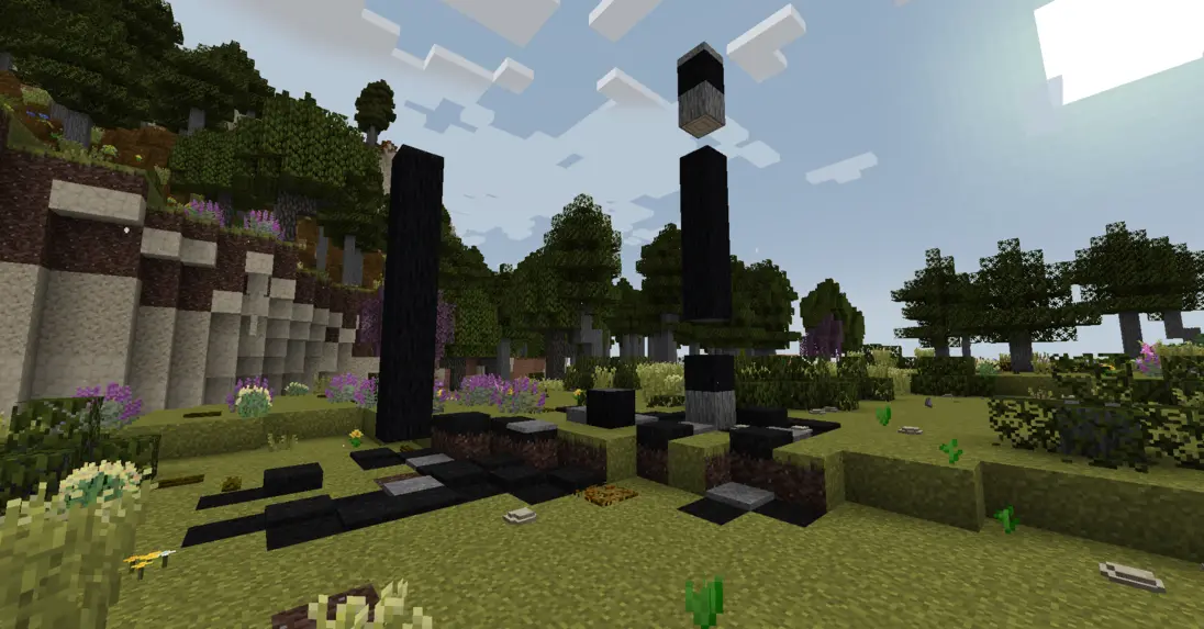 Two burned down trees on the a flat terrace with a forest in the background.