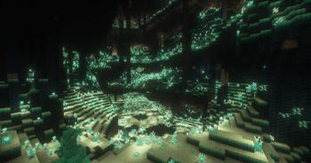 An open Glowroot Cave with tons of vertical height, and some pillars hanging from the ceiling.