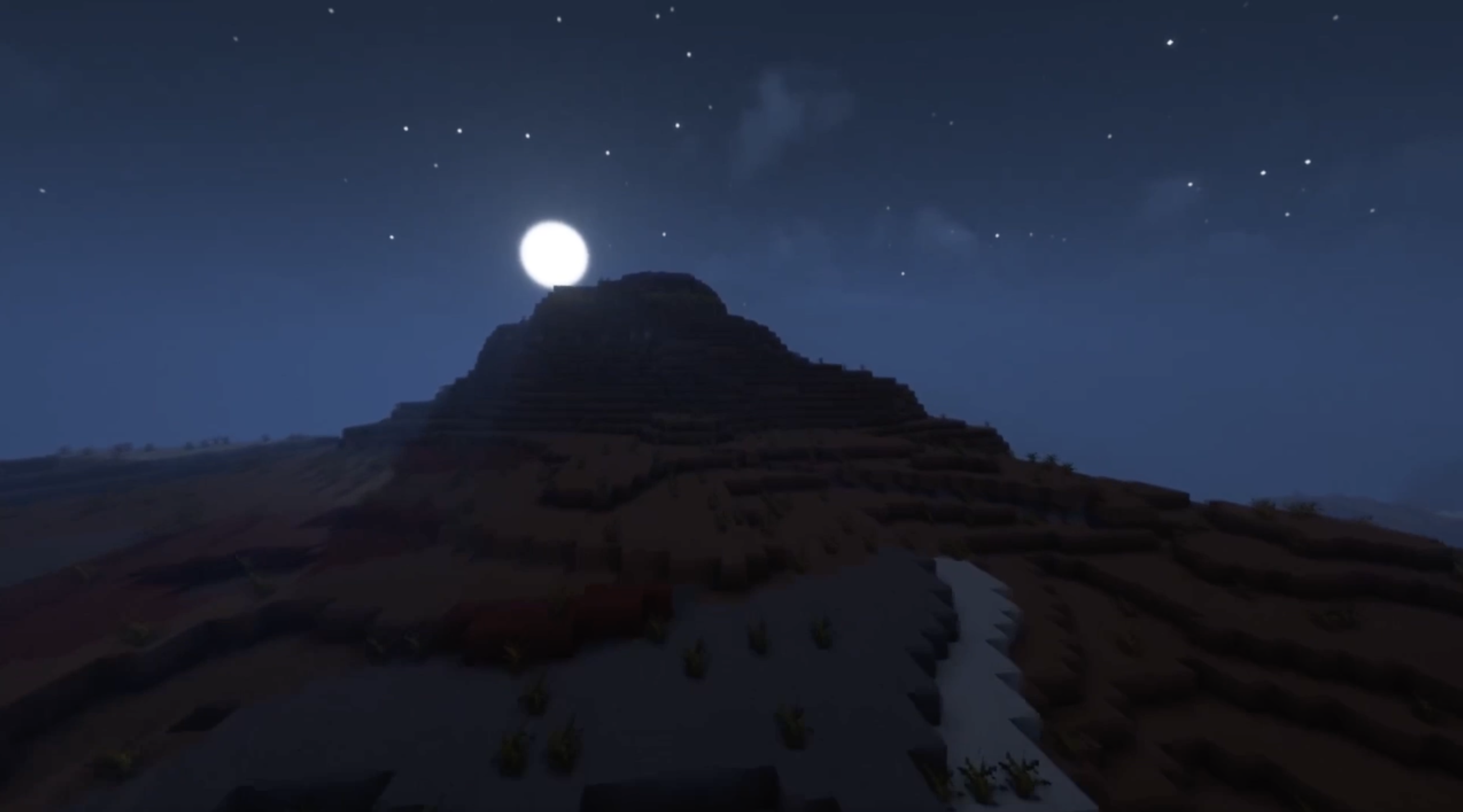 The moon shining over a hill in the mesa